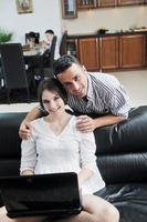 joyful couple relax and work on laptop computer at modern home photo