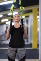 woman working out pull ups with gymnastic rings photo
