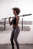 black woman lifting empty bar photo