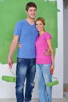 happy couple paint wall at new home photo