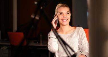 woman using mobile phone in dark office photo