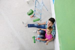 pareja joven feliz relajándose después de pintar en un nuevo hogar foto