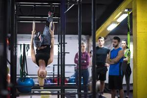 woman working out with personal trainer on gymnastic rings photo