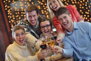 Group of happy young people drink wine at party photo