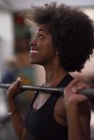 black woman lifting empty bar photo