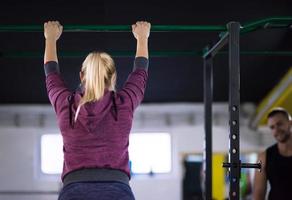 woman doing pull ups on the horizontal bar photo