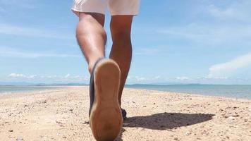 hombre caminando por la playa video