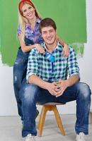 happy couple paint wall at new home photo