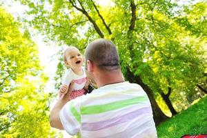 man and baby playing in park photo