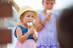 little girls eating ice cream by the sea photo