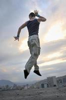 young man dancing and jumping  on top of the building photo