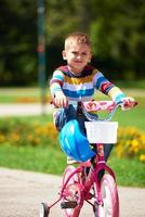niño feliz aprendiendo a andar en bicicleta foto