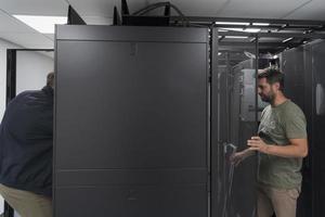 Technicians team updating hardware inspecting system performance in super computer server room or cryptocurrency mining farm. photo