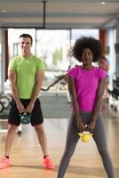 entrenamiento en pareja con pesas en el gimnasio crossfit foto