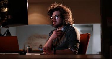 man working on computer in dark office photo