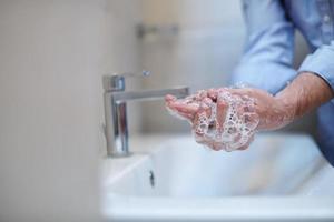 coronavirus masculino lavándose las manos en el baño foto