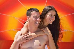 feliz pareja joven divertirse en la playa foto