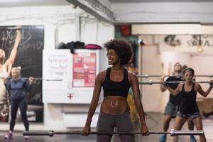 black woman lifting empty bar photo