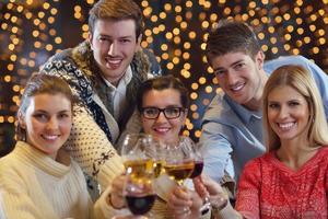 Group of happy young people drink wine at party photo