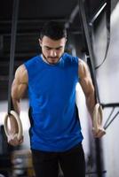 man working out pull ups with gymnastic rings photo