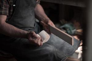 Manos tallando copa de madera, trabajando con cincel de cerca. taller de madera. proceso de fabricación de utensilios de cocina de madera foto