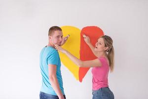 pareja está pintando un corazón en la pared foto