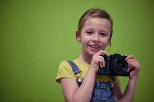 Cute little girl taking picture using  film photo camera