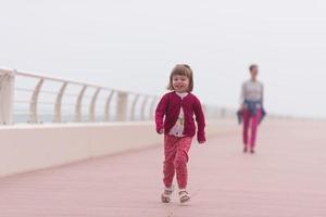 madre y niña linda en el paseo marítimo junto al mar foto