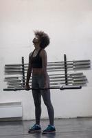 black woman lifting empty bar photo