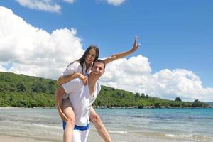 feliz pareja joven divertirse en la playa foto