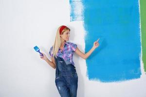 mujer sonriente feliz pintando el interior de la casa foto