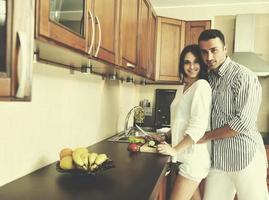 feliz pareja joven divertirse en la cocina moderna foto