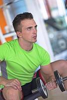 handsome man working out with dumbbells photo