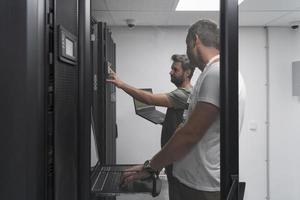 Technicians team updating hardware inspecting system performance in super computer server room or cryptocurrency mining farm. photo