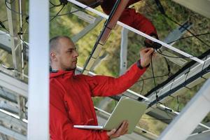 ingeniero que usa una computadora portátil en el campo de la planta de paneles solares foto