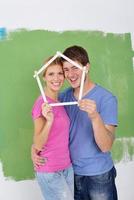 pareja feliz pintando una pared en su nuevo hogar foto