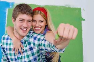 happy couple paint wall at new home photo