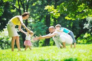 happy young couple with their children have fun at park photo