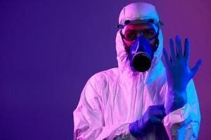 Doctor wearing protective biological suit and mask due to coronavirus photo