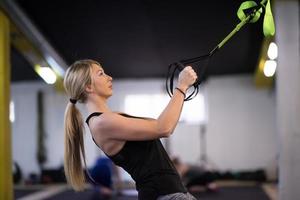 mujer trabajando en pull ups con anillos de gimnasia foto