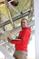 engineer using laptop at solar panels plant field photo