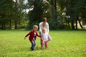 familia feliz jugando juntos al aire libre en el parque foto