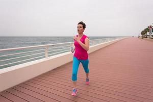 woman busy running on the promenade photo