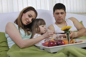 happy young family eat breakfast in bed photo