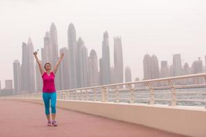 mujer joven celebrando una carrera de entrenamiento exitosa foto