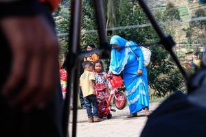 dieng, indonesia - 1 de agosto de 2015. festival cultural de dieng, los turistas siguen la procesión de rastas durante el evento del festival cultural de dieng en dieng, distrito de banjarnegara, java central foto