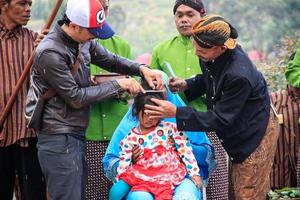 Dieng, Indonesia - August 1, 2015. Dieng Culture Festival, Tourists follow the dreadlocks procession during the Dieng Culture Festival event at Dieng, Banjarnegara district, Central Java photo