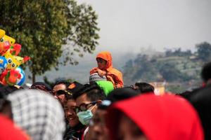 Dieng, Indonesia - August 1, 2015. Dieng Culture Festival, Tourists follow the dreadlocks procession during the Dieng Culture Festival event at Dieng, Banjarnegara district, Central Java photo