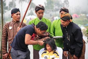 dieng, indonesia - 1 de agosto de 2015. festival cultural de dieng, los turistas siguen la procesión de rastas durante el evento del festival cultural de dieng en dieng, distrito de banjarnegara, java central foto