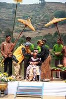 Dieng, Indonesia - August 1, 2015. Dieng Culture Festival, Tourists follow the dreadlocks procession during the Dieng Culture Festival event at Dieng, Banjarnegara district, Central Java photo